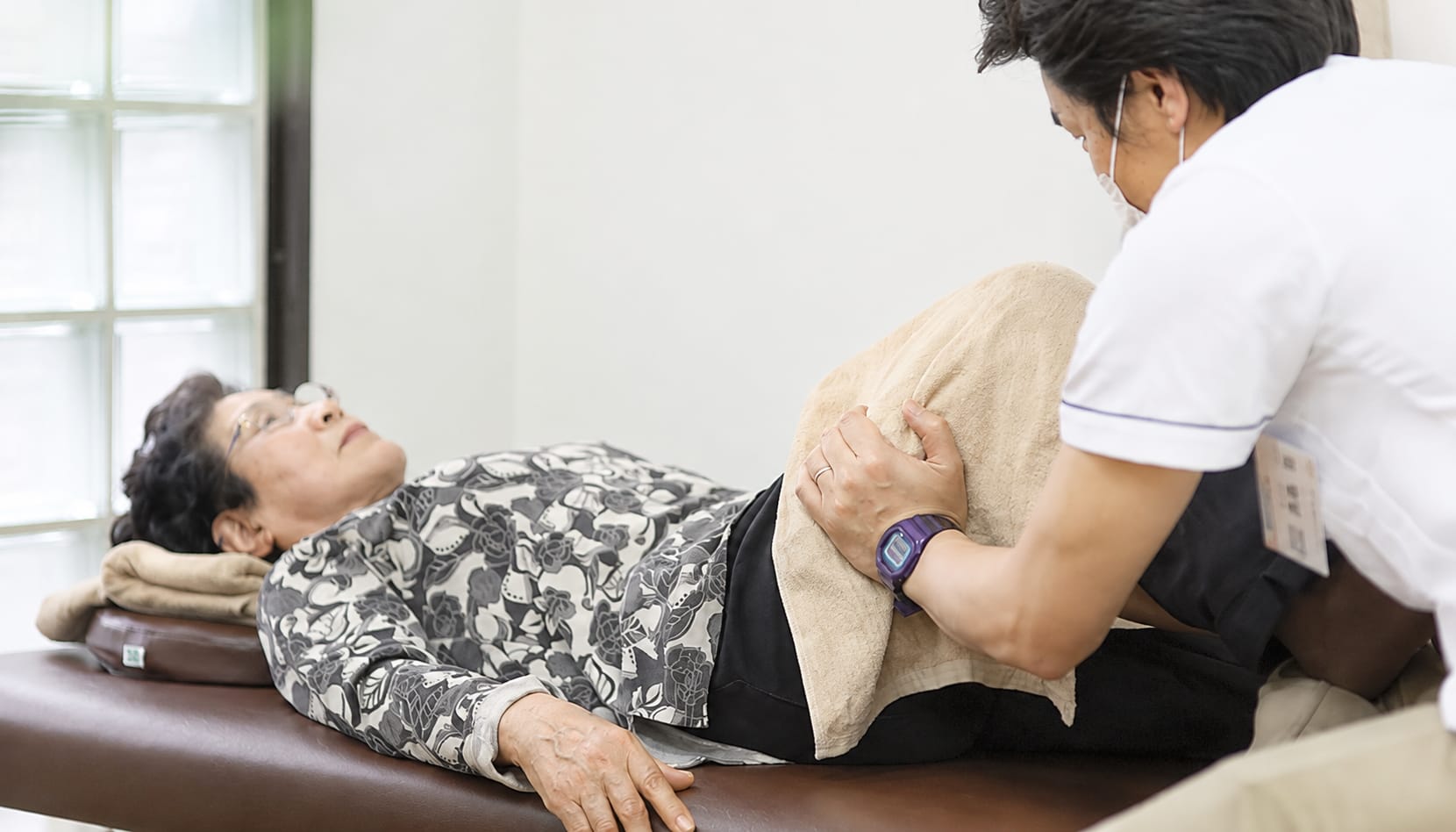 ベッドで介護整体を受けるご利用者様