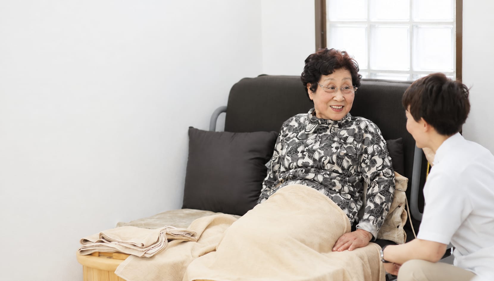 足元を温めながらスタッフと談笑するご利用者様